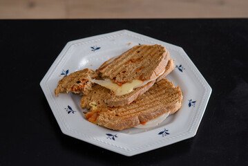 Sandwiches made of homemade bread toasted with ham, spreadable cheese and ketchup inside. Homemade food that is always good to start or end the day.