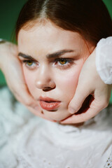 Captivating portrait of a young woman with expressive eyes, wearing a delicate white blouse,...