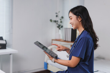 Smiling nurse using digital tablet in hospital room