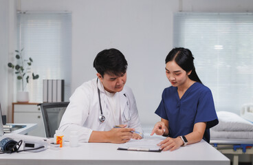 Doctor and nurse discussing medical chart in hospital room