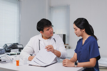 Doctor explaining medical report to nurse in hospital room