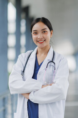 Portrait of smiling asian female doctor wearing white coat and stethoscope