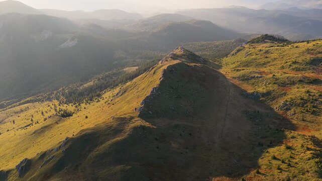 Drone aerial footage of sunlit alpine ridge and dramatic shadowed slopes in Bosnia