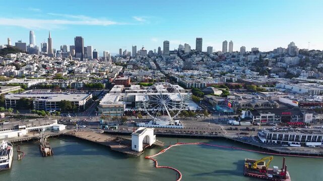 Aerial view of the cityscape featuring Pier 39, the Ferris wheel, and buildings in a dense urban environment, San Francisco, California, United States.