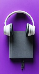 Book and headphones on purple. Top-down, close-up