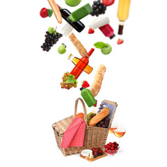 Picnic time. Various products fall into wicker basket against white background