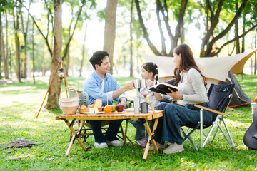 Happy parents and daughter Bakery and Bread Fruit enjoy  in a sunny garden. A joyful summer picnic...