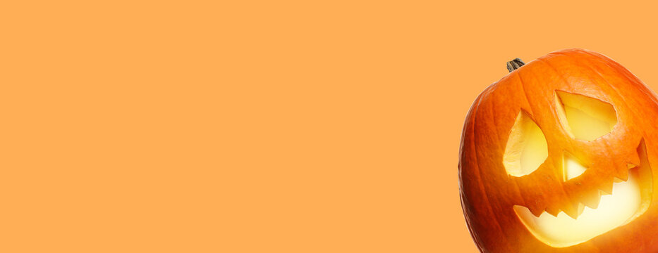 Halloween poster design with peeking jack-o-lantern against pale orange background. Space for text