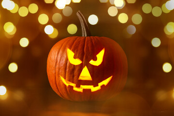 Halloween jack-o-lantern. Pumpkin with carved creepy face, bokeh effect