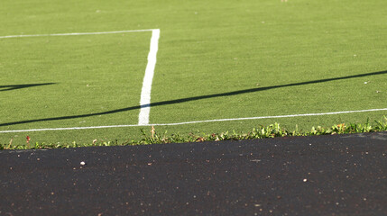 Obraz premium School sports stadium with green grass field and black pavement