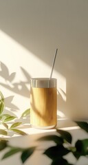 Drink in bamboo cup, straw, sunlit leaves & soft background