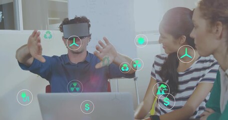 Man placing VR headset, gesturing as team viewing energy icons grouping around laptop for review - Powered by Adobe