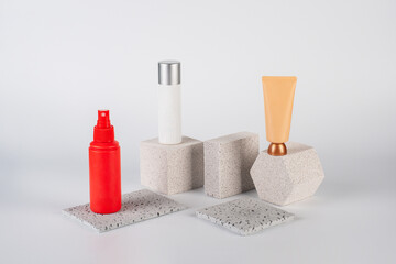 Cosmetic pink bottle. Womens cosmetic accessory for makeup with stylish props on cream background.