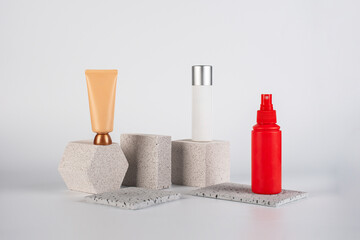 Cosmetic pink bottle. Womens cosmetic accessory for makeup with stylish props on cream background.