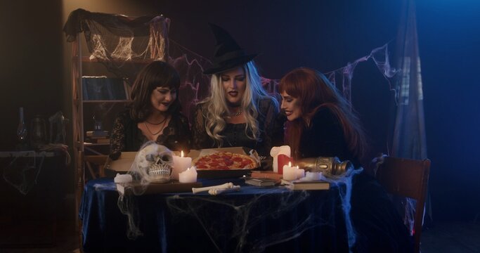 Three Witches Celebrating Halloween with Candlelit Ritual