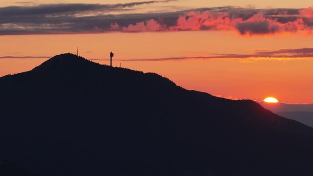 Golden sunset over Trebevic mountain silhouette with tower landmark