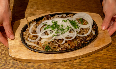 Delicious sizzling dish served with onions and herbs in a cozy restaurant setting