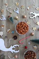 Various Christmas decorations, cookies, chocolate and nuts on wooden background. Flat lay.