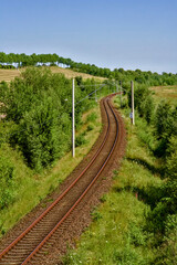 The railway track curves through the lush fields of the countryside, creating a picturesque view