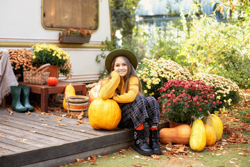 Beautiful smile young girl with long hair in knitted clothes with flowers chrysanthemums and...