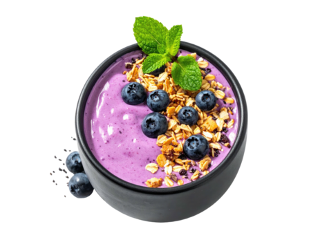 Purple smoothie bowl with granola, blueberries, and mint, isolated on black