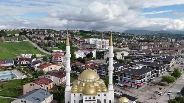 
A beautiful Turkish mosque with elegant Ottoman architecture, featuring majestic domes and tall minarets under the clear blue sky. The sunlight highlights intricate Islamic details and stone patterns