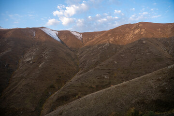 Peaceful mountain slope at sunrise with dramatic cloudscape