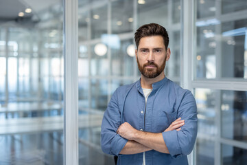 Confident man with beard standing in modern office
