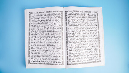 Obraz premium Open Quran book on blue background with copy space