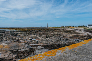 Rocky Atlantic Coast at Low Tide in Brittany France, Exposed Seabed with Orange Lichen, Seaweed, Granite Rocks, Coastal Village, Lighthouse, Finistere