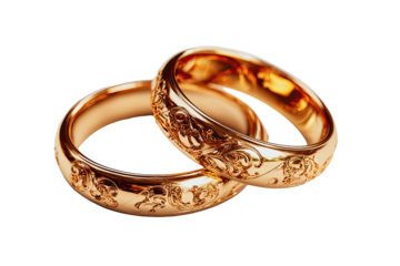 Two gold wedding bands, ornate with detailed carvings, rest atop one another