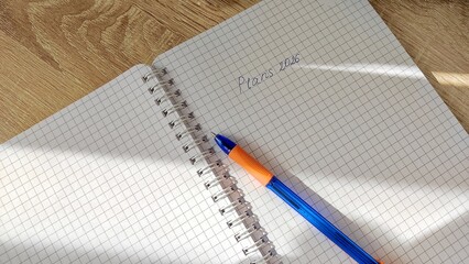 The process of writing plans for 2026 in a notebook, a woman sums up and writes down plans for the new year 2026