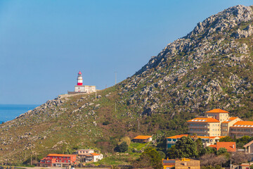 View of the Atlantic ocean, the lighthouse of Cabo Silleiro and coastal village in Galicia, Spain