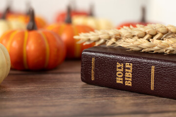 Holy bible with wheat and pumpkin on wooden background. Close-up. Christian thanksgiving concept.