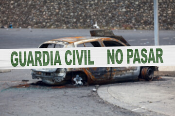 Obraz premium Spanish police tape in front of a burnt car