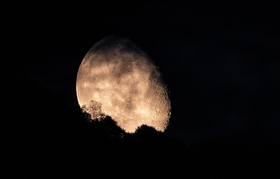 Aerial view of the moon shining brightly through the dark sky, its surface illuminated by the sun, creating a stark contrast with the surrounding darkness. Monte Are, Lugano , Switzerland