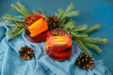 Warm Christmas mulled wine with orange slices and star anise on blue cloth