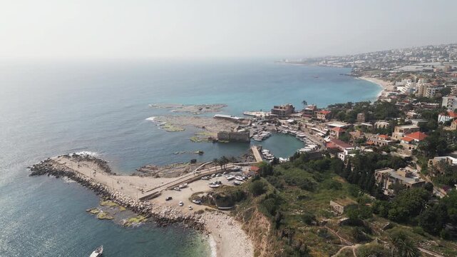 Aerial drone video showcase a scenic panorama pf Byblos, a small touristic town situeated on the Mediterranean shore in Lebanon. Flying forwards.