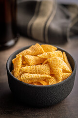 Bugles snack. Cone corn chips in bowl on kitchen table.