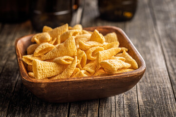 Bugles snack. Cone corn chips in bowl on wooden table.