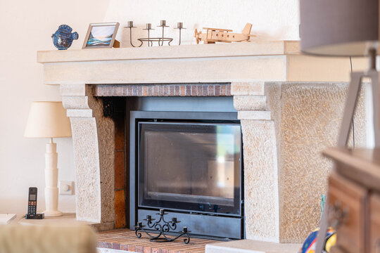 Chemin&eacute;e en pierre et insert moderne dans un salon lumineux du sud