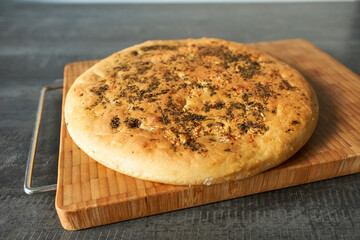 Traditional italian focaccia bread on wooden board, closeup