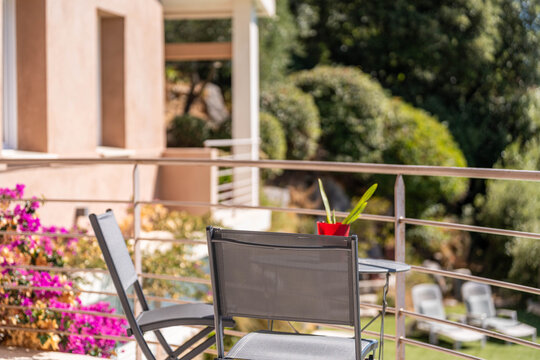 Terrasse fleurie avec chaises modernes et vue sur le jardin
