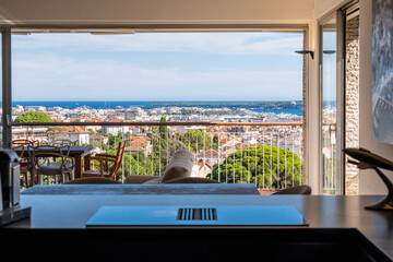 Fototapeta premium Modern apartment workspace with panoramic view over Cannes and the sea