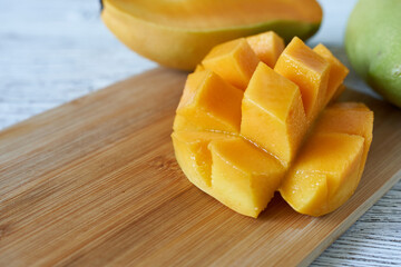 Mango slices on a wooden board, close-up, selective focus.