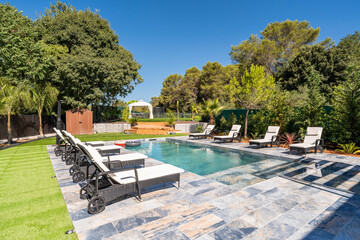 Luxury swimming pool with sun loungers in private garden