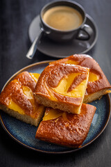 Catalana sponge cake on plate on black table.