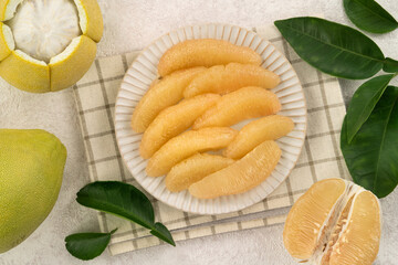 Fresh pomelo fruit with leaf on white table background.