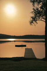 Romantic jetty on the lake at sunset with calm water