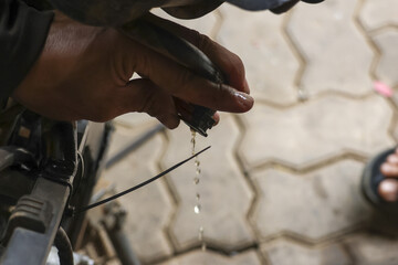 Close up of hand holding rag, wiping away oil dripping from mechanical part, conveying sense of...